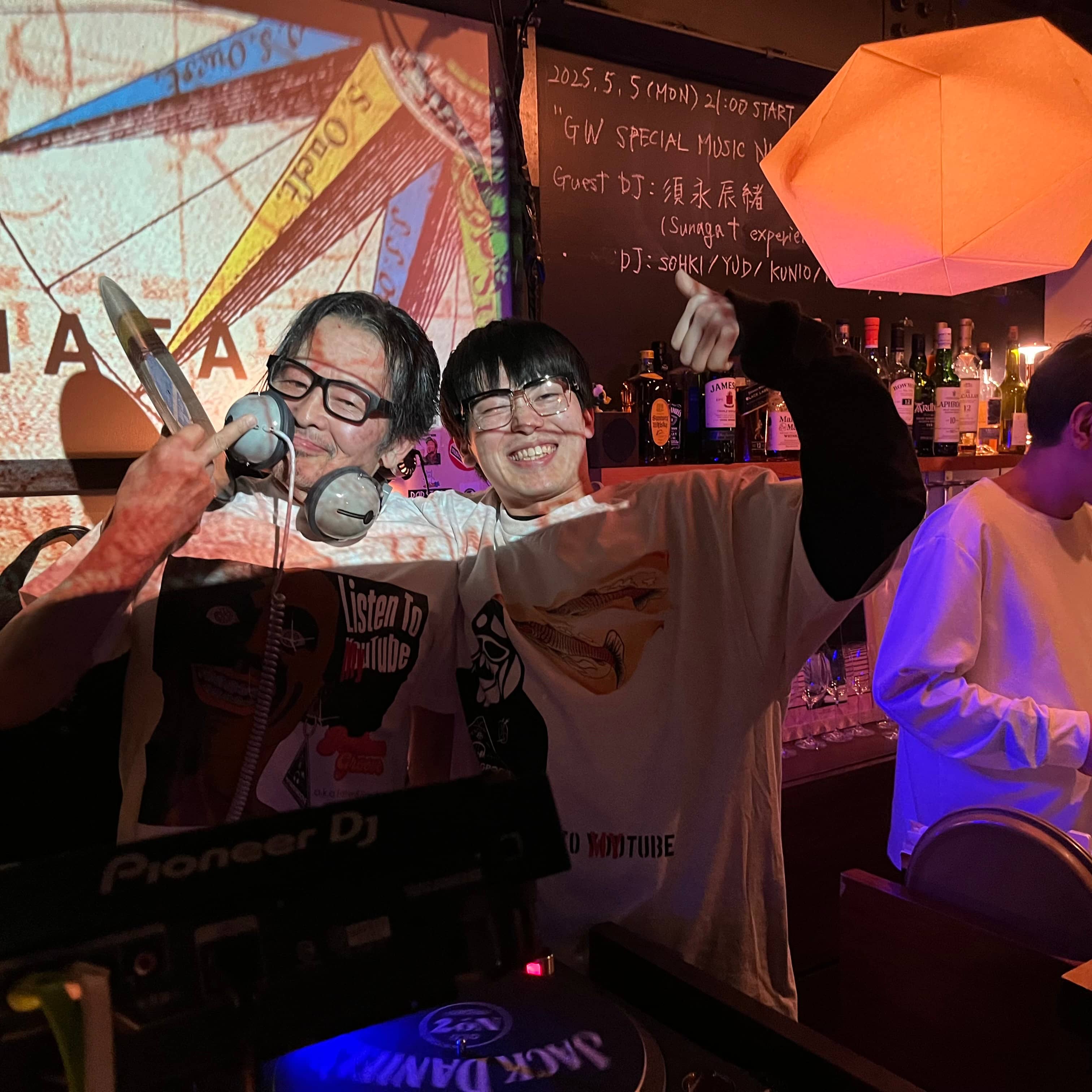 プロジェクション演出の中でポーズを取るDJと観客